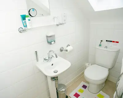 a white bathroom with a toilet and a sink at Craig Park House in Airdrie