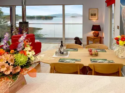 a room with tables and chairs and a large window at Tidereach - Otters View in Connel
