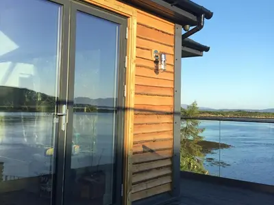 a view from the outside of a house with a large glass door at Tidereach - Otters View in Connel