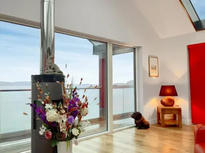 a dog sitting in a living room with a fireplace at Tidereach - Otters View in Connel