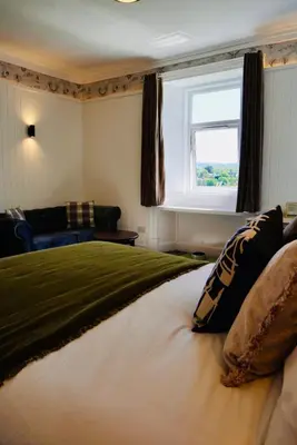 a bedroom with a large bed and a window at Lochnell Arms Hotel in Oban