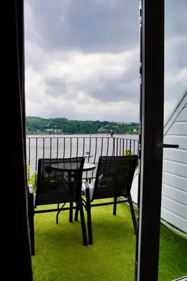 a balcony with a table and chairs and a view of the water at Lochnell Arms Hotel in Oban