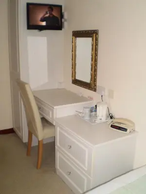 a bathroom with a white sink and a mirror at Shawlee Cottage in Airdrie