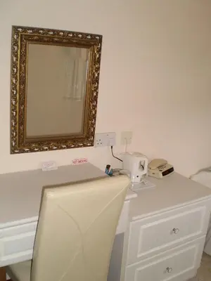 a mirror on the wall above a white desk at Shawlee Cottage in Airdrie