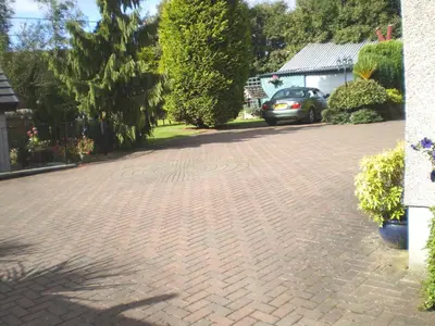 a brick driveway with a car parked on it at Shawlee Cottage in Airdrie