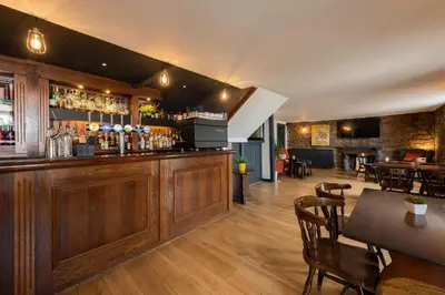 a bar in a restaurant with a table and chairs at The Smiddy Haugh in Auchterarder