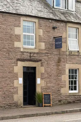 a brick building with a sign in front of it at The Smiddy Haugh in Auchterarder