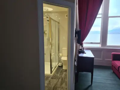 a bathroom with a shower and a toilet and a window at St.Ebba B&B in Rothesay