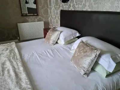 a white bed with four pillows on it at St.Ebba B&B in Rothesay