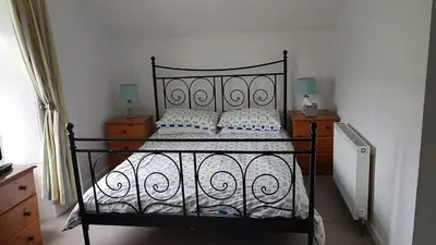 a bedroom with a black bed with white sheets and pillows at St.Ebba B&B in Rothesay