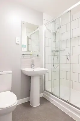 a white bathroom with a sink and a shower at The Great Western Hotel in Oban