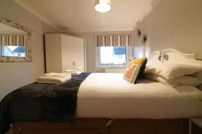 a bedroom with a large bed with white sheets at Signature - Stanfield House in Motherwell