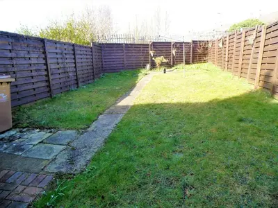 a backyard with a fence and a grass yard at Signature - Stanfield House in Motherwell