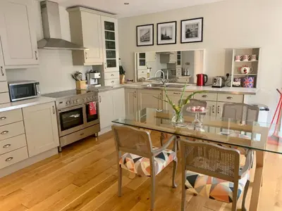 a kitchen with a glass table and two chairs at Stylish City Centre Apartment in Edinburgh