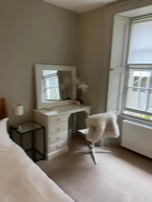 a bedroom with a desk with a mirror and a chair at Stylish City Centre Apartment in Edinburgh