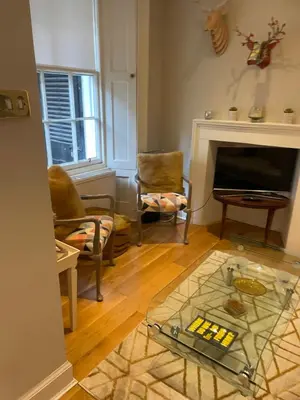 a living room with a glass table in front of a fireplace at Stylish City Centre Apartment in Edinburgh