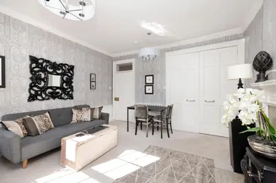 a living room with a couch and a table at Elegant Flat Near Princes Street - Perfect Location, 24-7 Customer Support in Edinburgh