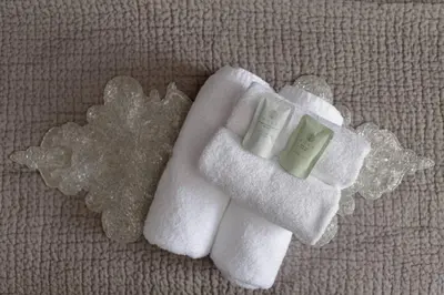 two towels and two bottles of soap on a pillow at Elegant Flat Near Princes Street - Perfect Location, 24-7 Customer Support in Edinburgh