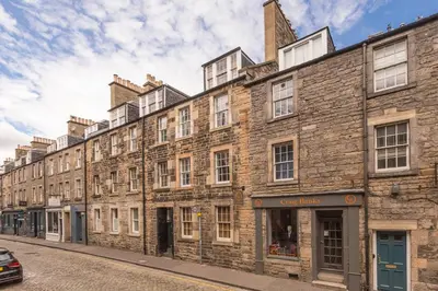 a large brick building on the side of a street at Elegant Flat Near Princes Street - Perfect Location, 24-7 Customer Support in Edinburgh