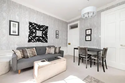 a living room with a couch and a table at Elegant Flat Near Princes Street - Perfect Location, 24-7 Customer Support in Edinburgh