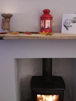 a fireplace with a red lantern on a shelf at Beside the Bay in Millport