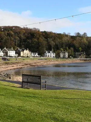 a park bench sitting next to a body of water at Beside the Bay in Millport