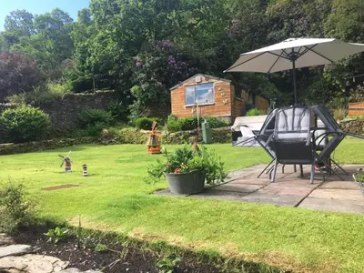 a chair and an umbrella in a yard at Montague Villa in Dunoon