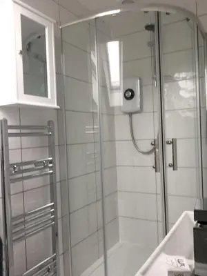 a shower with a glass door in a bathroom at Montague Villa in Dunoon