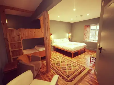 a bedroom with a bed and a couch and a chair at Comrie Croft in Crieff