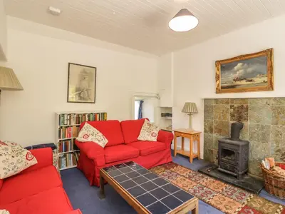 a living room with a red couch and a fireplace at Balmeanoch in Lochearnhead