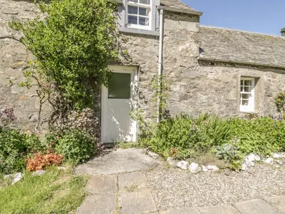 a stone house with a door and a window at Balmeanoch in Lochearnhead