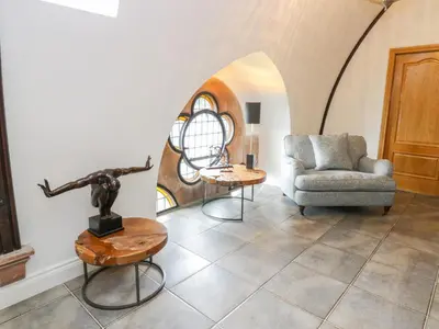 a living room with a couch and a chair at Penthouse St Mary's Church in Moffat