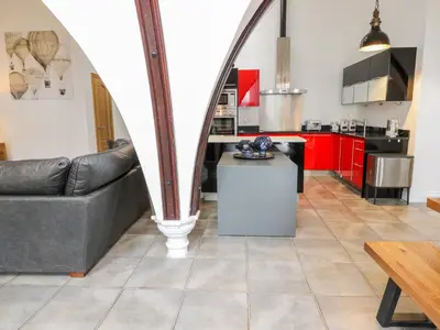 a living room with a couch and a kitchen at Penthouse St Mary's Church in Moffat