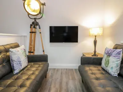 a living room with two couches and a flat screen tv at Penthouse St Mary's Church in Moffat