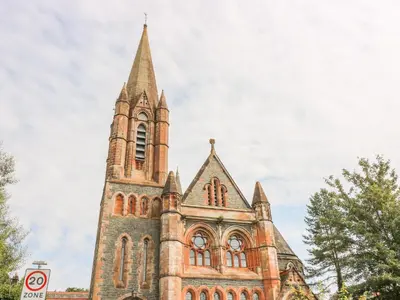 an old church with a tower with a steeple at Apartment 1 St Mary's Church in Moffat