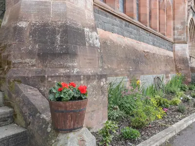 a pot of red flowers on the side of a building at Duplex in Moffat