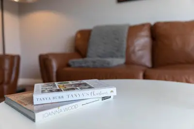 two books sitting on top of a table with a couch at Stunning 1 Bed Merchant City Apartment with Parking in Glasgow