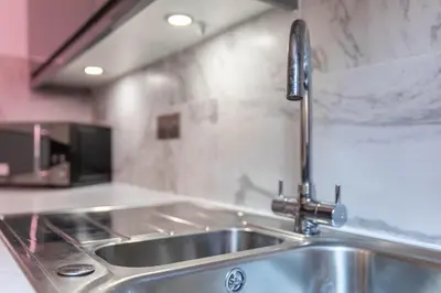 a kitchen sink with a faucet on a counter at Stunning 1 Bed Merchant City Apartment with Parking in Glasgow