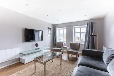 a living room with a couch and a table at Stunning 2 Bed Merchant City Apartment with Residents Parking (Bell 2) in Glasgow