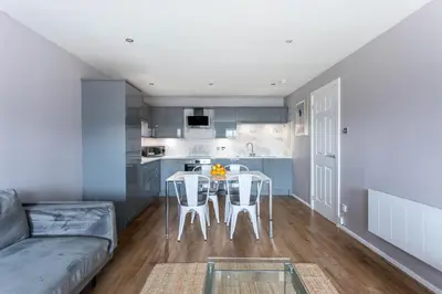 a living room with a couch and a table and chairs at Stunning 2 Bed Merchant City Apartment with Residents Parking (Bell 2) in Glasgow
