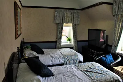 a hotel room with two beds and a television at Loch Arklet House in Stirling