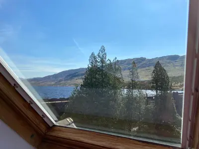 a window with a view of a lake and mountains at Loch Arklet House in Stirling