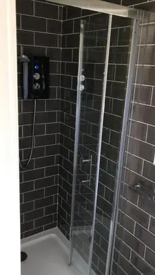 a shower with a glass door in a bathroom at Fasgadh Rooms in Tarbert