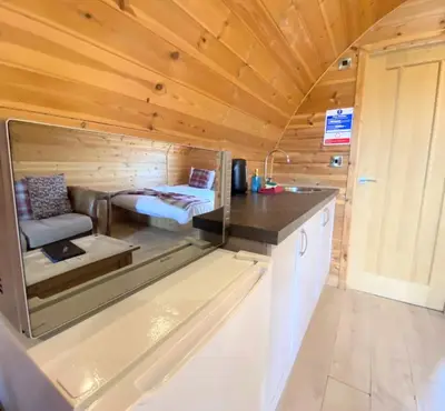 a tiny house with a kitchen and a bed at Pond View Pod 1 with Outdoor Hot Tub - Fife - Loch Leven - Lomond Hills in Kelty