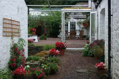 a garden with flowers in pots and a building at Craigadam Country House Hotel in Kirkpatrick Durham