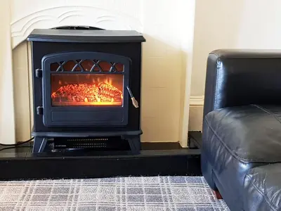a stove sitting in a living room with a couch at Glen View Apartments in Port Glasgow