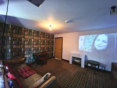 a living room with a couch and a large screen at Lbtie Lodge with Two Private Hot Tubs - Fife - Loch Leven - Lomond Hills in Kelty