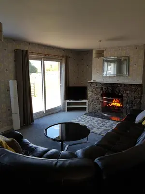a living room with a couch and a fireplace at Cleughfoot House in Moffat