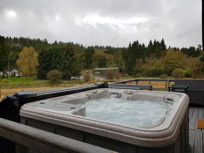 a hot tub sitting on top of a deck at Cleughfoot House in Moffat