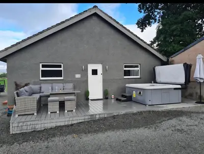 a backyard patio with a couch and a table at Cleughfoot House in Moffat